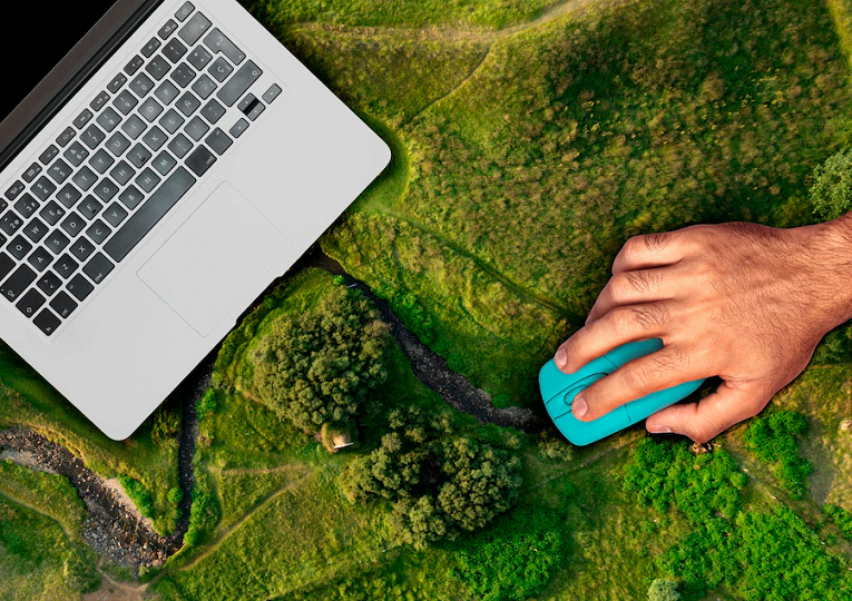 Лаптоп и мишка за лаптоп на фона на зелена гора