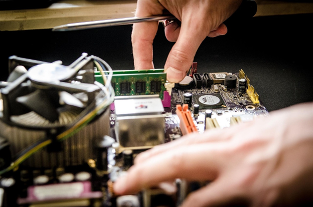 Мъж разглобява старо електронно устройство за рециклиране